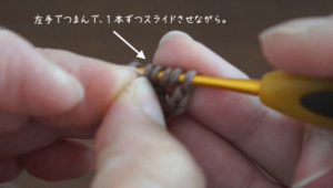 埼玉県所沢市の編み物教室poponnnerが教える動画レッスンの様子。コイル編みのモチーフを編んでいる様子の画像。左手を使いながら糸をくぐらせる様子。