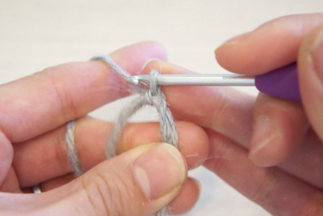 二重の輪で作り目を作る円の編み方を説明しています。二重の輪から糸を引き出し、再度糸を巻きつけ作り目を作る様子です。