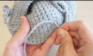 どうぶつポシェットを組み立てています。糸端はポシェットの内側で編み目に隠すように綴じます。