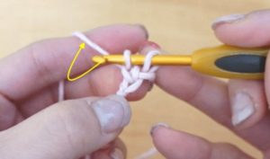 かぎ針編みで伸縮する作り目を編んでいます。糸をもう一度巻きつけます。